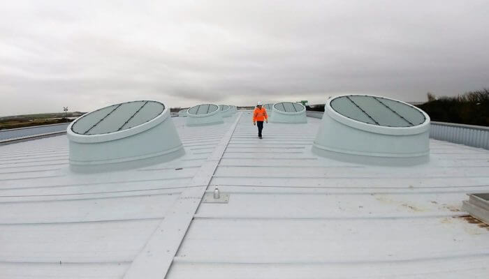 Commercial roof penetrations, with man on roof inspecting