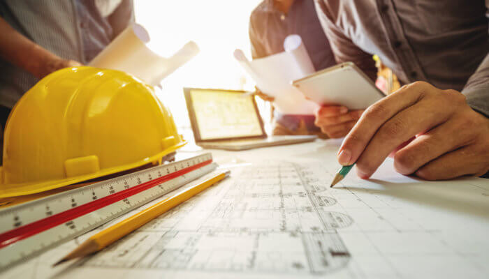 Three technical leads examining roof details for a roofing project